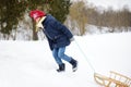 Funny little girl having fun with a sleigh in beautiful winter park. Cute child playing in a snow. Royalty Free Stock Photo