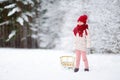 Funny little girl having fun with a sleight in beautiful winter park Royalty Free Stock Photo