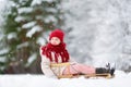 Funny little girl having fun with a sleight in beautiful winter park Royalty Free Stock Photo