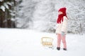 Funny little girl having fun with a sleight in beautiful winter park Royalty Free Stock Photo
