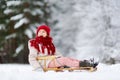 Funny little girl having fun with a sleight in beautiful winter park Royalty Free Stock Photo