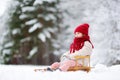 Funny little girl having fun with a sleight in beautiful winter park Royalty Free Stock Photo