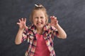 Funny little girl imitating angry tiger on dark background Royalty Free Stock Photo