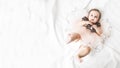 Funny little girl in a pink dress. Portrait of a cute baby 6 months old lying on a white blanket. Handsome baby. Looks into the Royalty Free Stock Photo