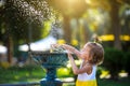 A funny little girl is playing with the spray of a drinking water fountain in the park. Childhood, child, summer time, heat. Solar Royalty Free Stock Photo