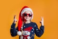 Funny little girl in Santa Claus hat and sunglasses having fun. Happy New Year and Merry Christmas Royalty Free Stock Photo