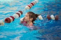 a funny little girl swims in inflatable armbands in a pool near the buoys. Royalty Free Stock Photo