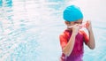 Funny little girl swims in a pool