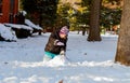 Funny little girl in a warm winter outfit, building snow man. Kid playing outdoors in .