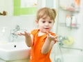 Funny little girl washing hands in bathroom Royalty Free Stock Photo