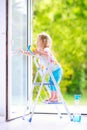 Funny little girl washing a window Royalty Free Stock Photo