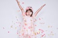 Funny little girl wearing pink dress in tulle with princess crown on head on white background rise hands up enjoy Royalty Free Stock Photo