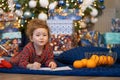 Little girl writing letter to santa. happy kid making a wish, gift, present on new year eve. child dreaming under the christmas Royalty Free Stock Photo