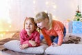 Funny little girls laugh and talk, posing lying on floor and on Royalty Free Stock Photo