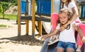 funny little girls on playground. playing children on slide