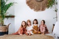 Funny little girls of the same age sitting on the floor in tropical style room