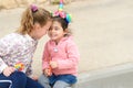 Two happy young girls in a city street. Toddler girl dressing up as a unicorn.