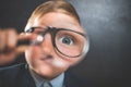 Funny little kid boy looking through a magnifying glass. Big eye. Royalty Free Stock Photo