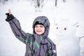 Funny little kid boy making a snowman and eating carrot, playing having fun with snow, outdoors on cold day. Active leisure childr