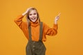 Funny little kid girl 12-13 years old in turtleneck, jumpsuit isolated on orange yellow background. Childhood lifestyle Royalty Free Stock Photo