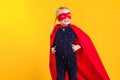 Funny little power superhero child girl in a red raincoat and a mask. Superhero concept.