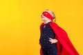 Funny little power superhero child girl in a red raincoat and a mask. Superhero concept.