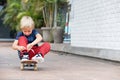 Funny little skater with skateboard before lesson