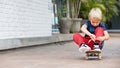 Funny little skater with skateboard before lesson