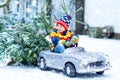 Funny little smiling kid boy driving toy car with Christmas tree. Royalty Free Stock Photo