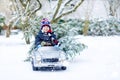 Funny little smiling kid boy driving toy car with Christmas tree. Royalty Free Stock Photo