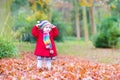 Funny little toddler girl playing in autumn park Royalty Free Stock Photo