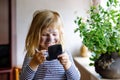 Funny little toddler girl using mother`s make up and painting face with eye shadows. Happy baby child making experiments Royalty Free Stock Photo