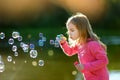 Funny lovely little girl blowing soap bubbles