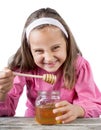 funny lovely little girl eat honey Royalty Free Stock Photo