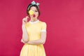 Funny lovely pinup girl covered one eye with yellow lollipop