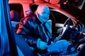 Funny male driver in a leather jacket in the car in the dark. Night photo shoot