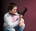 Funny male photographer looking into camera lens, man in studio Royalty Free Stock Photo