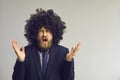 Funny man in afro hair wig angry shouting and gesturing at camera studio shot Royalty Free Stock Photo