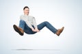 Funny man in casual clothes makes a jump over a gymnastic obstacle, on a light blue background. Royalty Free Stock Photo