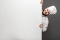 Cheerful chef emerging from behind whiteboard Royalty Free Stock Photo