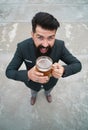 Funny man in classical suit holding glass with beer in hand. Smiling man with beer. Bartender, happy brewer. Full length