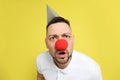 Funny man with clown nose and party hat on background. April fool`s day Royalty Free Stock Photo