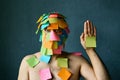 Funny man with colorful sticky notes all over his face and body show palm hand Royalty Free Stock Photo