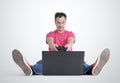 Funny man gamer sitting on the floor playing on laptop Royalty Free Stock Photo