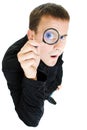 Funny man looking through a magnifying glass.