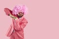 Funny man in pink party suit, clown wig and funky glasses dancing on pink copy space background