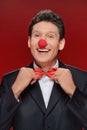 Funny man. Portrait of cheerful man with a clown nose touching h Royalty Free Stock Photo