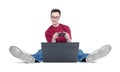 Funny man in round glasses, sitting on the floor and playing games on laptop. on white background Royalty Free Stock Photo