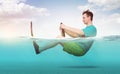 Funny man in shorts, T-shirt and flippers rides on the sea with a car steering wheel. Concept of going on vacation Royalty Free Stock Photo