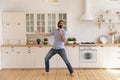 Funny man singing into kitchenware, dancing, having fun in kitchen Royalty Free Stock Photo